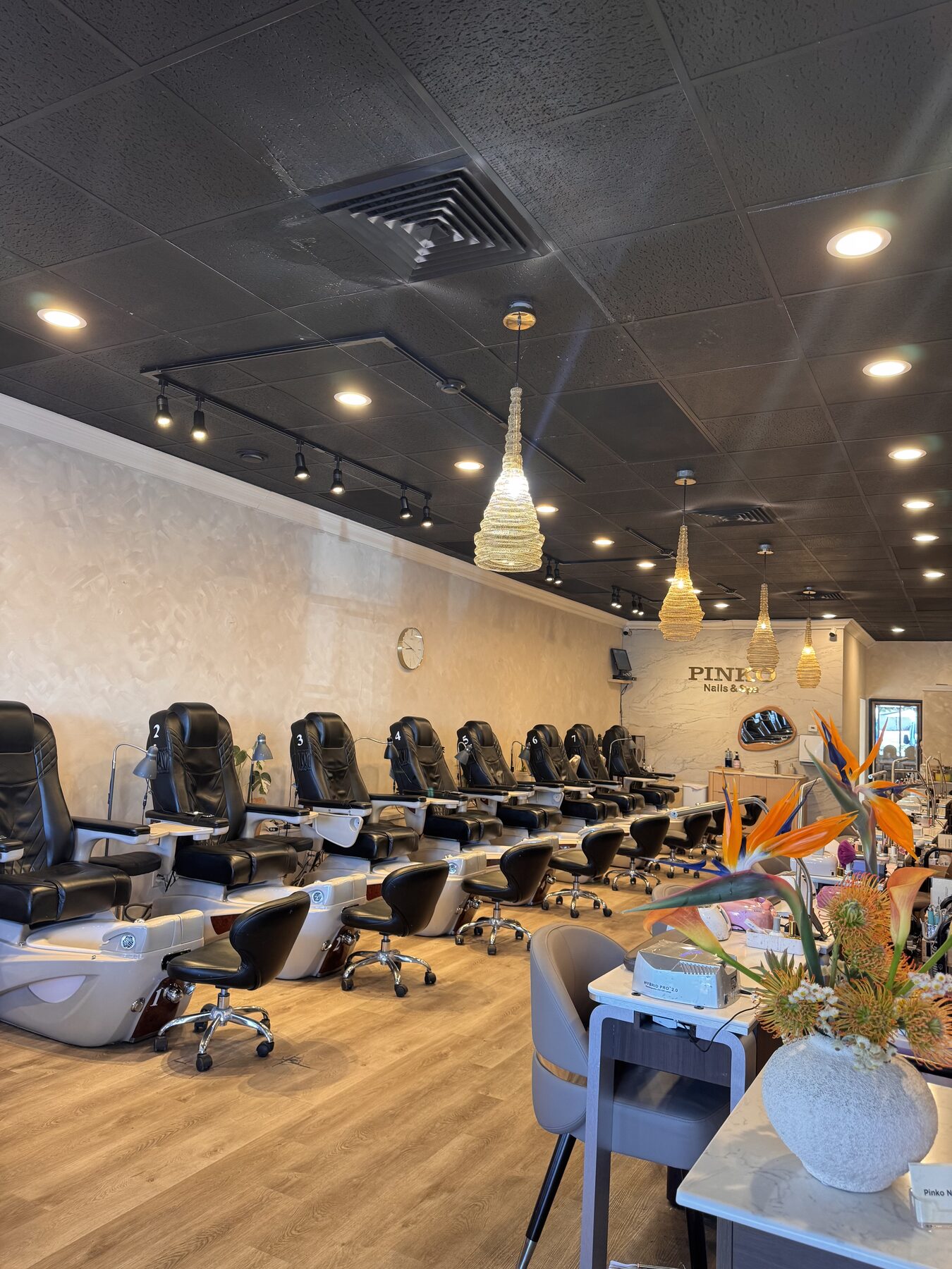 Numbered pedicure stations with woven gold pendant lights.